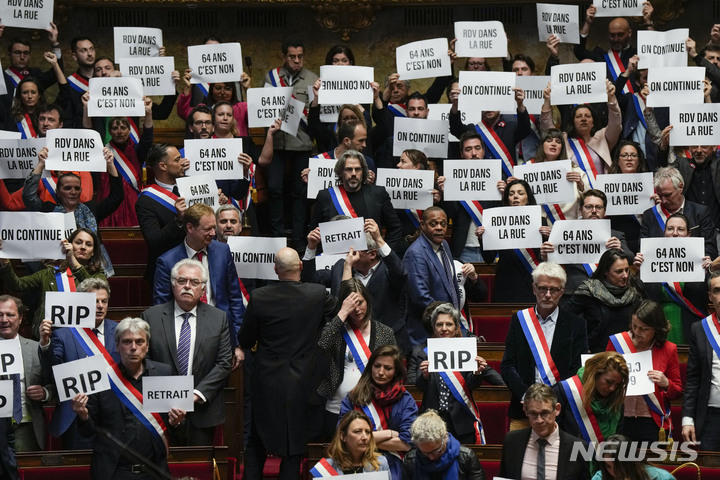 [파리=AP/뉴시스] 프랑스 하원에서 엘리자베트 보른 총리에 대한 불신임안이 부결되자 야당 의원들이 피켓을 들고 일어나 항의하고 있다. 2023.03.20.