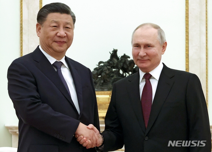 [모스크바=AP/뉴시스] 시진핑(왼쪽) 중국 국가주석과 블라디미르 푸틴 러시아 대통령이 20일(현지시간) 러시아 모스크바 크렘린궁에서 열린 비공식 회담에 앞서 악수하고 있다. 2023.03.21.