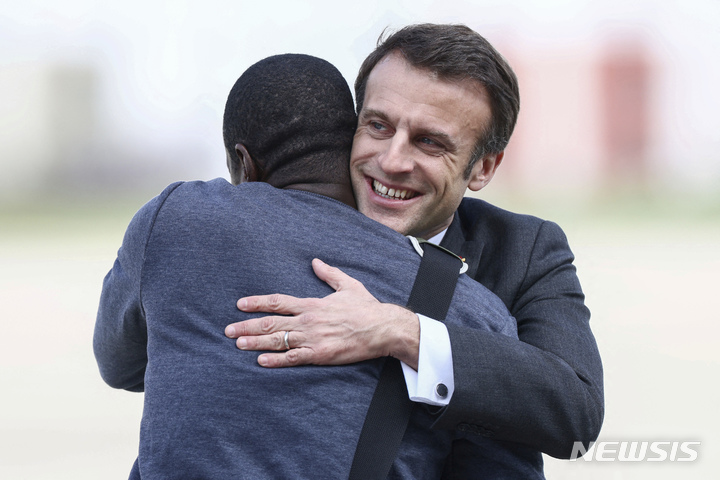 [파리= AP/뉴시스] 엠마뉘엘 마크롱 프랑스대통령이 3월 21일 파리 근교 비야쿠블레 군 공항에서 말리에서 2년만에 석방된 올리비에 뒤보아 기자를 맞아 포옹하고 있다.  