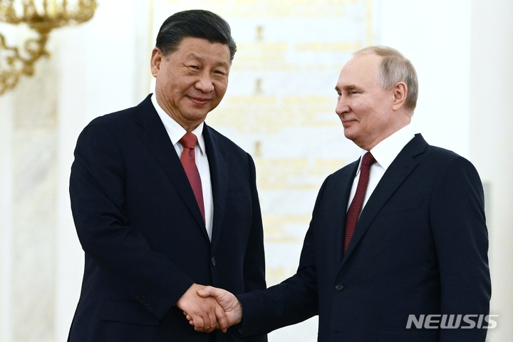 [서울=AP/뉴시스]블라디미르 푸틴 러시아 대통령과 시진핑 중국 국가주석이 21일(현지시간) 러시아 모스크바 크렘린 대궁전에서 열린 공식 환영식에서 악수를 하고 있다. 