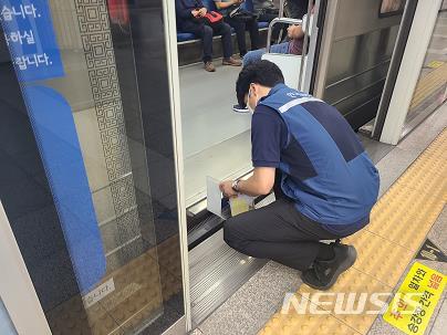 [서울=뉴시스] 한국교통안전공단 직원이 승강장과 전동차와의 간격·단차 적정 여부를 점검하고 있다. (사진=교통안전공단 제공)