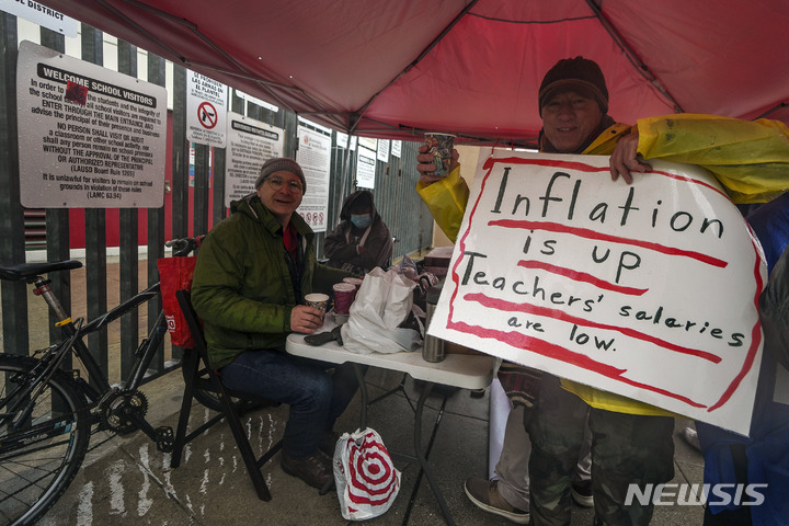 [로스앤젤레스=AP/뉴시스]로스앤젤레스 학교 파업에 참가한 영어교사 게리 오브라이언이 에반스 커뮤니티 성인 학교 앞에서 3월 21일 인플레이션에 따른 임금인상을 요구하는 팻말을 들고 있다.