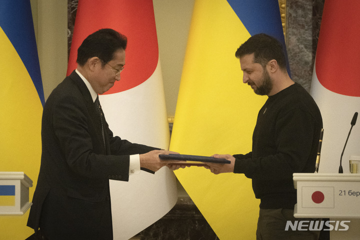 [키이우=AP/뉴시스] 우크라이나를 방문한 기시다 후미오(왼쪽) 일본 총리가 21일(현지시간) 키이우에서 볼로디미르 젤렌스키 우크라이나 대통령과 공동 기자회견 후 문서를 교환하고 있다. 기시다 총리는 "일본은 우크라이나의 평화가 회복될 때까지 지원할 것"이라고 말했다. 2023.03.22.