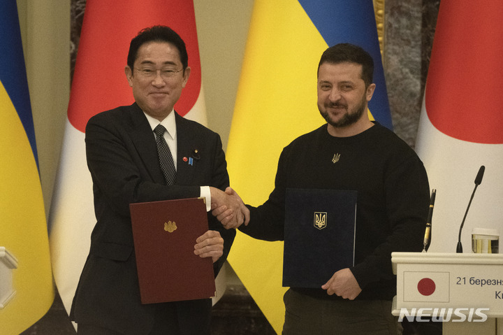 [키이우=AP/뉴시스]기시다 후미오 일본 총리(왼쪽)와 볼로디미르 젤렌스키 우크라이나 대통령이 지난 21일(현지시간) 우크라이나 키이우에서 공동문서에 서명한 후 악수를 나누고 있다. 2023.03.28.