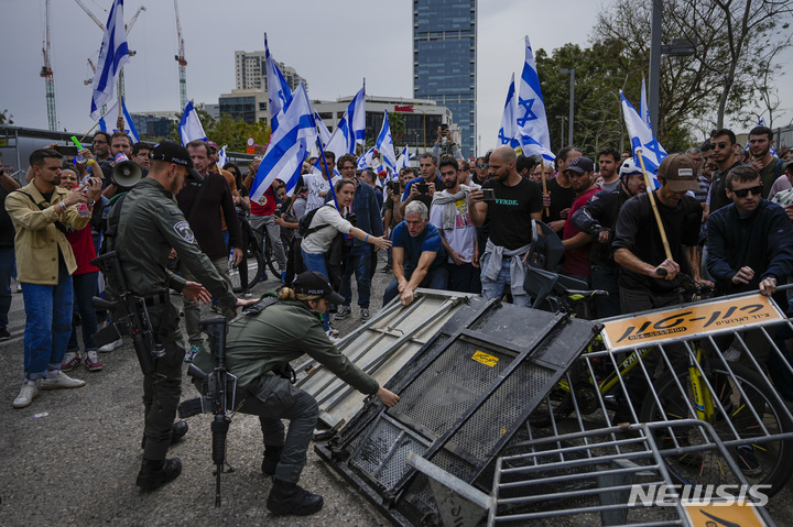 [텔아비브=AP/뉴시스] 23일(현지시간) 이스라엘 텔아비브에서 경찰이 도로를 막고 시위하는 사법 개혁 반대 시위대와 충돌하고 있다. 연일 이어지는 항의 시위에도 이스라엘 의회는 사법 개혁의 몇 가지 법안 중 첫 번째 법안을 통과시켰다. 베냐민 네타냐후 총리는 사법 개혁안을 통과시키겠다는 입장을 고수하면서 향후 야권과 반대 세력의 의견을 수렴하겠다고도 전했다. 2023.03.24.