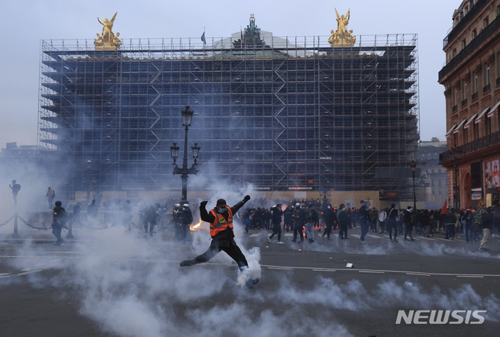 [파리=AP/뉴시스] 23일(현지시간) 프랑스 수도 파리에서 열린 연금개혁 반대 대규모 시위에서 시위대가 최루탄을 발로 차고 있다. 2023.03.24.