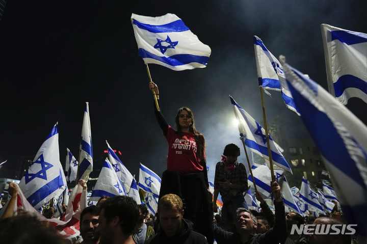 [텔아비브=AP/뉴시스]26일(현지시간) 이스라엘 텔아비브에서 사법 개혁 반대 시위대가 고속도로를 막고 시위를 벌이고 있다. 2023.03.27