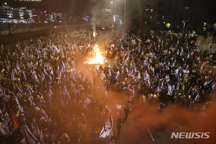 [텔아비브=AP/뉴시스] 26일(현지시간) 사법개혁 반대 시위대가 이스라엘 텔아비브에서 고속도로를 막고 집회를 하고 있다. 2023.03.27