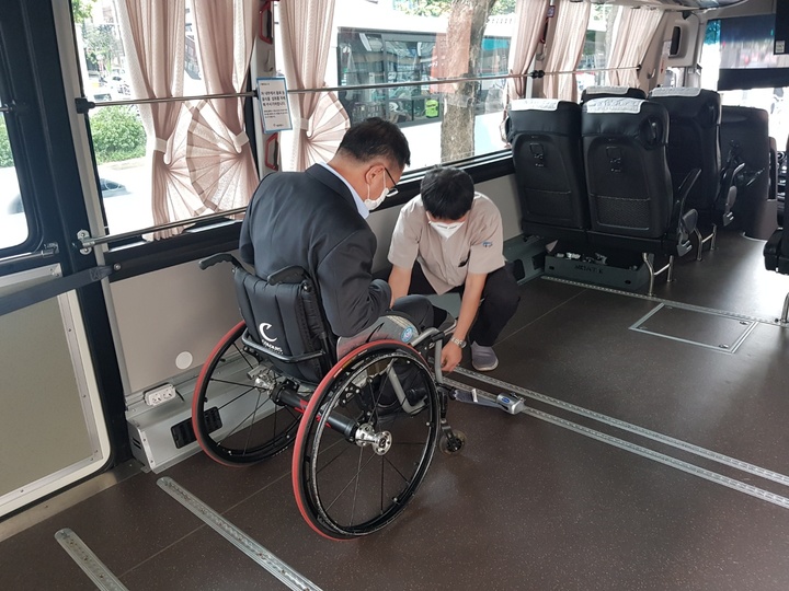 [서울=뉴시스] 휠체어를 탄 장애인의 버스이용 모습.(사진=관악구 제공)