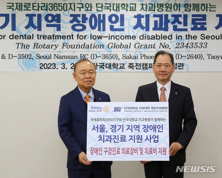 [용인=뉴시스] 손봉락 국제로타리 3650지구 총재(왼쪽)가 김수복 단국대 총장에게 장애인 치료지원과 전용장비 구입을 위한 기금을 전달했다.
