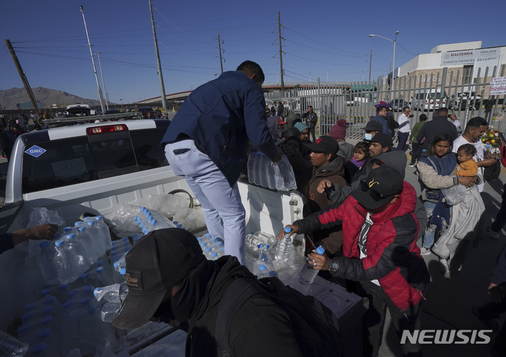 [치우다드후아레스( 멕시코)= AP/뉴시스] 멕시코 국경의 치우다드 후아레스 국립 이민수용소 화재 참사로 40명이 사망한뒤 몰려든 유족들에게 3월 28일 자원봉사자가 생수를 나눠주고 있다. 