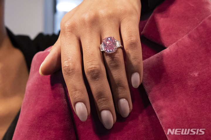 [뉴욕=AP/뉴시스] 지난 27일(현지시간) 미국 뉴욕의 소더비에서 한 여성이 10.57캐럿짜리 핑크 다이아몬드 반지를 끼고 포즈를 취하고 있다. '이터널 핑크'(Eternal Pink)라는 이름의 이 다이아몬드는 6월 8일 소더비 경매에 나와 3500만 달러(한화 약 457억 원)에 낙찰될 것으로 예상된다. 2023.03.30.