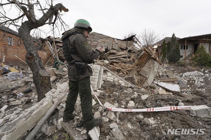 [하르키우=AP/뉴시스]우크라이나 군인이 지난달 31일 우크라이나 하르키우에서 러시아 로켓에 의해 파괴된 집의 상황을 기록하는 모습. 2023.03.31