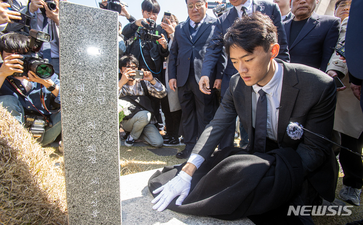 [광주=뉴시스] 김혜인 기자 = 고(故) 전두환씨의 손자인 전우원씨가 31일 오전 광주 북구 국립5 ·18민주묘지 내 김경철 열사의 묘소를 찾아 자신의 옷으로 묘비를 닦으며 넋을 위로하고 있다. 2023.03.31. hyein0342@newsis.com