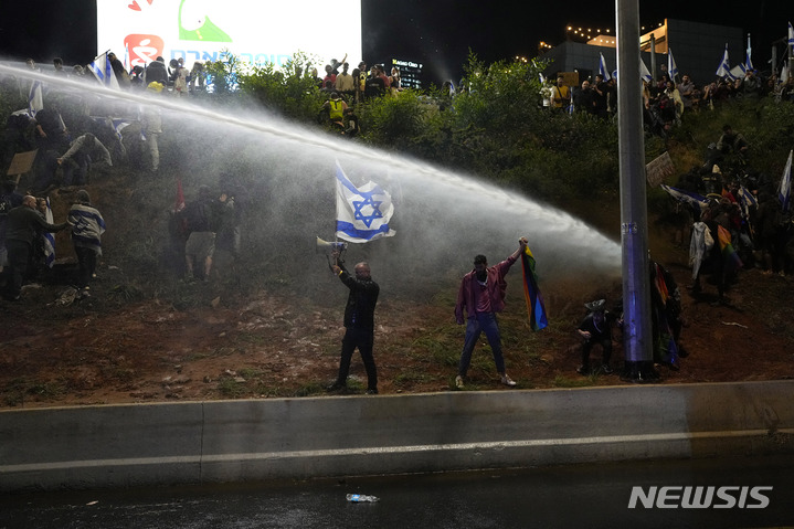 [텔아비브( 이스라엘)= AP/뉴시스] 이스라엘 남부 대도시 텔아비브 시내에서 4월 1일 (현지시간) 경찰이 네타냐후의 사법개혁에 반대하는 주말 시위대를 향해 물대포를 발사하고 있다.  