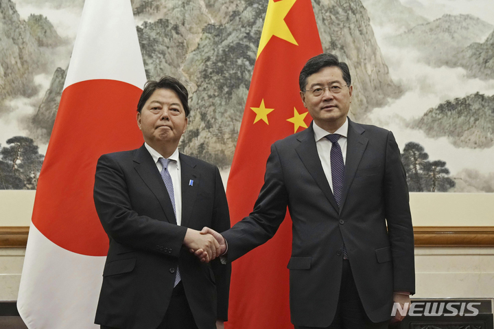 [AP/뉴시스] 일본의 하야시 요시마사 외무상(왼쪽)과 중국의 친강 외교부장이 2일 베이징 댜오유타이 영빈관에서 만나 악수 포즈를 취하고 있다