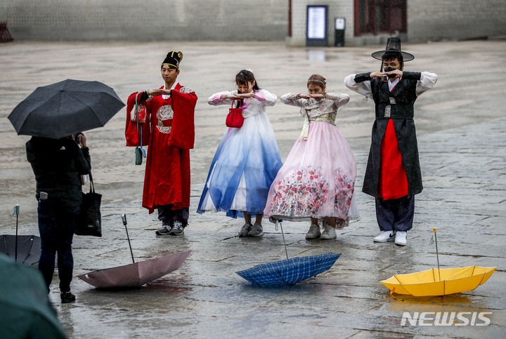 [서울=뉴시스] 정병혁 기자 = 비가 내린 5일 오후 서울 종로구 경복궁을 찾은 여행객들이 우산을 내려놓은 채 기념사진을 찍고 있다. 2023.04.05. jhope@newsis.com