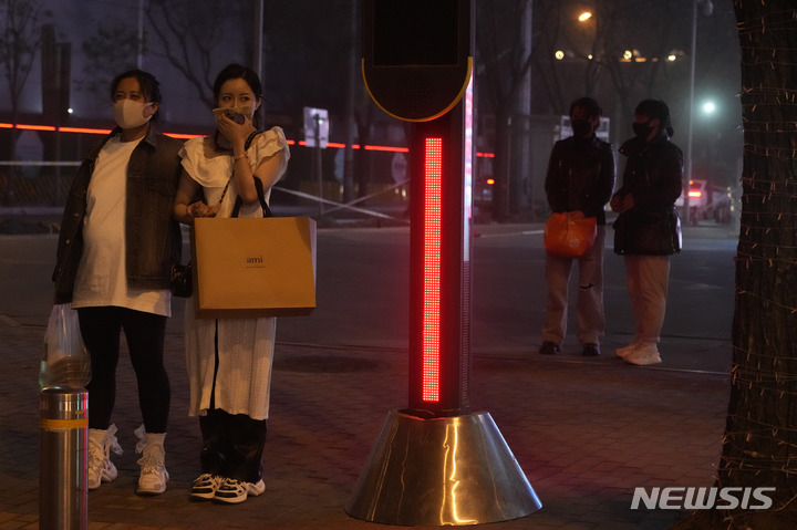 [베이징=AP/뉴시스] 10일 중국 베이징에서 한 여성이 스카프로 코와 입을 막으며 모래폭풍을 피하고 있다. 황사와 모래폭풍이 이날 밤 베이징을 덮쳐 대기지수(AQI)가 치솟았다. 2023.04.11.
