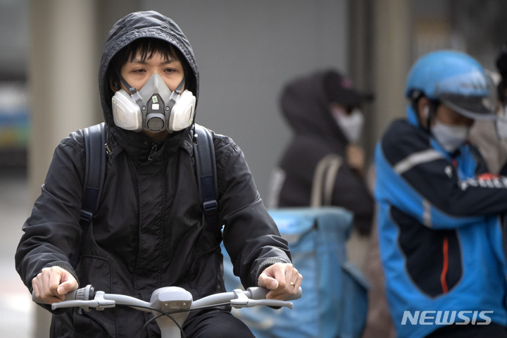[베이징=AP/뉴시스] 11일 중국 베이징 시내에 황사가 불어닥치자 한 주민이 호흡기를 착용한 채 자전거를 몰고 있다. 전날 밤부터 베이징을 덮친 황사와 모래폭풍으로 강풍 경보와 황사 경보가 동시에 발령됐다. 2023.04.11.