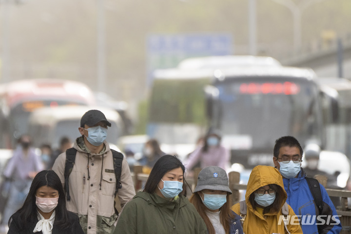 [베이징=AP/뉴시스] 11일 중국 베이징에서 출근길 시민들이 마스크를 쓴 채 황사에 뒤덮인 시내를 지나고 있다. 전날 밤부터 베이징을 덮친 황사와 모래폭풍으로 강풍 경보와 황사 경보가 동시에 발령됐다. 2023.04.11.