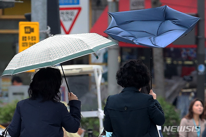 [서울=뉴시스] 조성우 기자 = 서울 지역에 강풍주의보가 내려진 11일 오후 서울 동작구 거리에서 한 시민이 쓴 우산이 뒤집히고 있다. 2023.04.11. xconfind@newsis.com