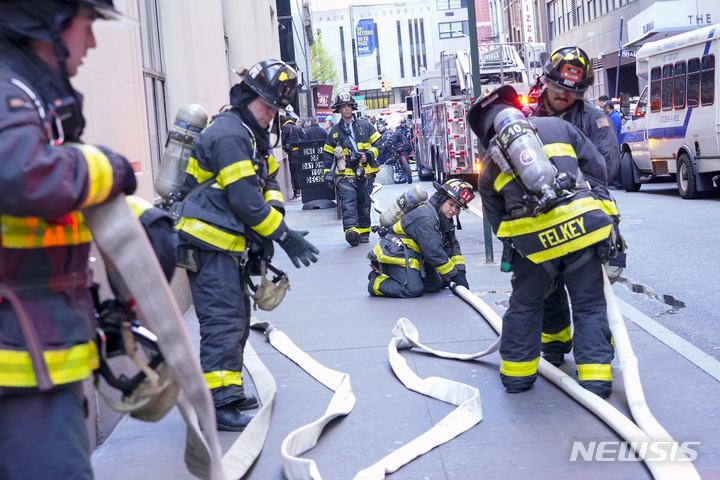 Firefighters work at the scene of a partial collapse of a parking garage in the Financial District of New York, Tuesday, April 18, 2023. (AP Photo/Mary Altaffer)