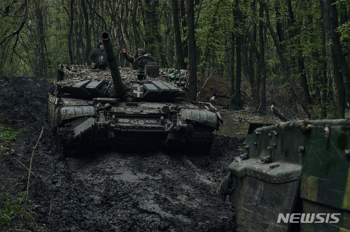 [바흐무트=AP/뉴시스] 4월23일 우크라이나 바흐무트 전선을 지나는 전차에서 우크라이나 군인들이 손을 흔들고 있다. 2024.04.24.
