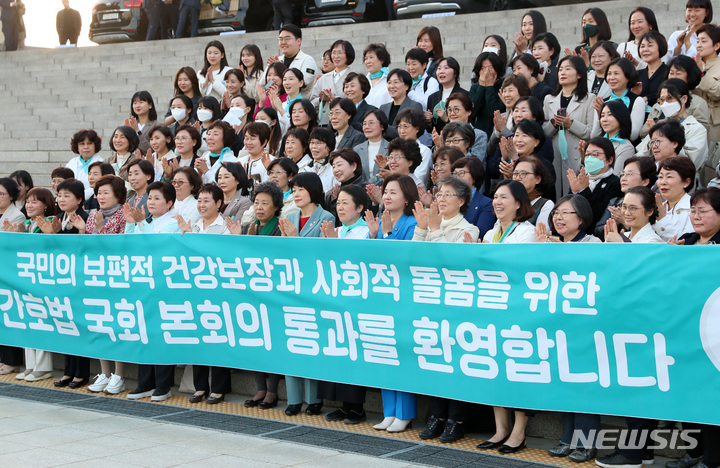 [서울=뉴시스] 이영환 기자 = 27일 오후 서울 여의도 국회 본회의장에서 열린 제405회국회(임시회) 제5차 본회의에서 간호법안(대안)에 대한 수정안이 재적 300인, 재석 181인, 찬성 179인, 반대 0인, 기권 2인으로 통과되자 대한간호협회 회원들이 본청 앞에서 기념촬영을 하고 있다. 2023.04.27. 20hwan@newsis.com