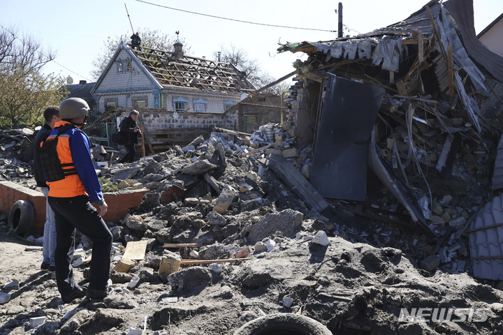 [자포리자=AP/뉴시스] 지난달 3일(현지시간) 우크라이나 자포리자에서 러시아군의 포격으로 파괴된 건물을 몇 사람이 바라보고 있다. 2023.06.09.