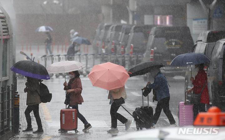 [제주=뉴시스] 우장호 기자 = 어린이날 황금연휴를 앞둔 4일 오전 제주국제공항 1층 도착장에 우산을 쓴 관광객들이 발걸음을 재촉하고 있다. 기상청에 따르면 오는 6일 오전까지 제주를 포함한 전국 대부분 지역에 강한 바람을 동반한 많은 비가 내릴 것으로 전망된다. 2023.05.04. woo1223@newsis.com