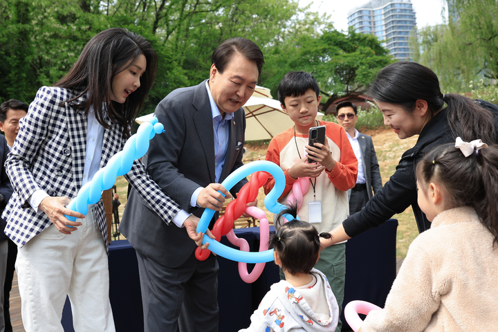 [서울=뉴시스] 윤석열 대통령과 부인 김건희 여사가 4일 서울 용산 대통령실 앞 미군기지 반환부지에 조성된 용산어린이정원에서 어린이들에게 풍선을 선물하고 있다. (사진=대통령실 제공) 2023.05.04. photo@newsis.com *재판매 및 DB 금지