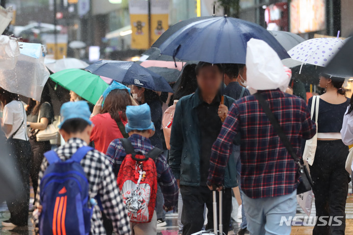 [서울=뉴시스] 권창회 기자 = 전국에 비가 내리고 있는 지난 5월 5일 오후 서울 중구 명동거리에서 관광객들이 머리에 비닐을 쓰고 이동하고 있다. 2023.05.05. kch0523@newsis.com
