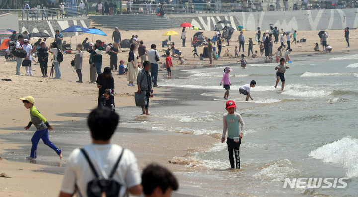 [부산=뉴시스] 하경민 기자 = 14일 부산 해운대구 해운대해수욕장을 찾은 시민과 관광객들이 물놀이를 하거나 일광욕을 즐기고 있다. 2023.05.14. yulnetphoto@newsis.com