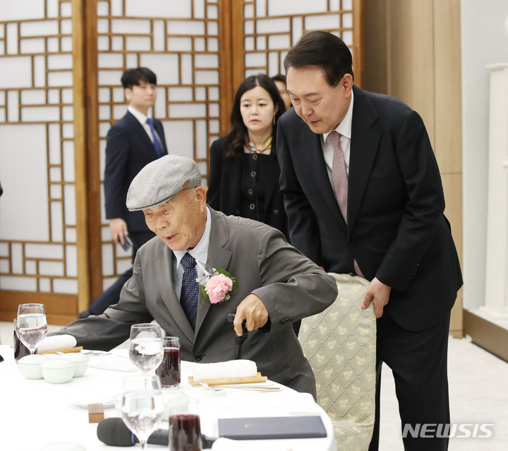 [서울=뉴시스] 전신 기자 = 윤석열 대통령이 15일 서울 용산 대통령실 청사에서 열린 제42회 스승의 날 기념 현장교원 초청 오찬 간담회에서 윤 대통령의 충암고 시절 은사인 최윤복 선생님의 착석을 도와주고 있다. 2023.05.15. photo1006@newsis.com