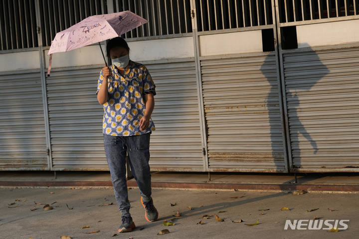 [방콕(태국)=AP/뉴시스]이상 폭염이 찾아온 태국 방콕에서 지난달 22일 한 여성이 살인적 햇볕을 막기 위해 양산을 들고 있다. 지난달 남아시아 일부 국가에서 나타난 이상 폭염과 같은 극단적 더위가 발생할 가능성이 기후변화로 인해 최소 30배 이상 높아졌다는 연구 결과를 기후변화의 영향을 연구하는 '세계기상기여'(World Weather Attribution)가 17일 발표했다. 2023.05.17.