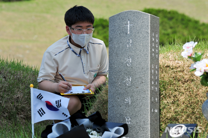 [광주=뉴시스] 이영주 기자 = 5·18민주화운동 43주기를 하루 앞둔 17일 오전 광주 북구 운정동 국립5·18민주묘지에서 현장학습을 온 지역 중학생이 고 김경철 열사의 묘소에 들러 공부하고 있다. 2023.05.17. leeyj2578@newsis.com