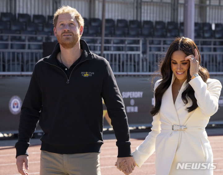 [AP/뉴시스] 영국의 해리왕자와 부인 메간이 지난 해 4월 17일 네델란드 헤이그의 한 경기장에 손을 잡고 들어서고 있다. 