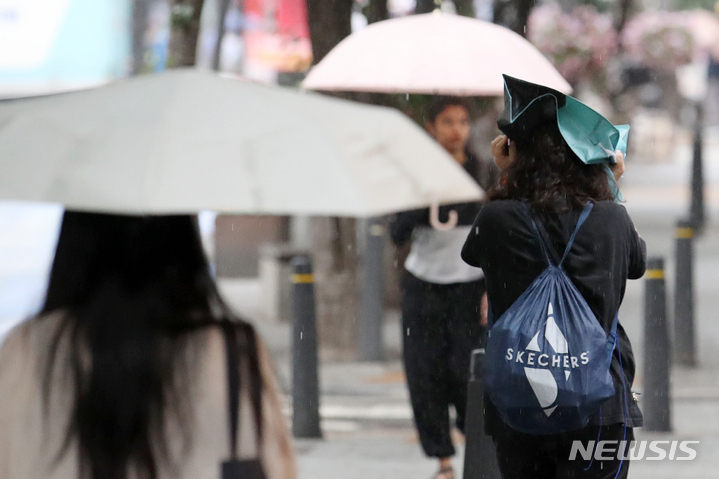 [서울=뉴시스] 조성우 기자 = 비가 내리는 지난달 18일 오후 서울 신촌 거리에서 한 시민이 가방을 머리에 쓰고 이동하고 있다. 2023.05.18. xconfind@newsis.com
