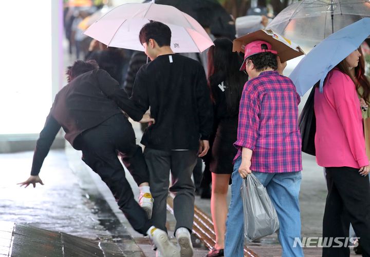 [서울=뉴시스] 조성우 기자 = 비가 내리는 지난달 18일 오후 서울 신촌 거리에서 한 시민이 미끄러져 넘어지고 있다. 2023.05.18. xconfind@newsis.com
