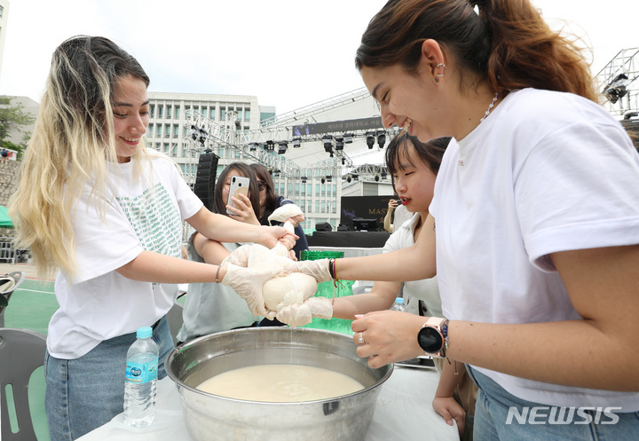 [서울=뉴시스] 김진아 기자 = 24일 서울 동대문구 경희대학교에서 열린 대동제 축제에 참여하는 외국인 유학생 등 학생들이 우리나라 전통주 만들기 체험을 하고 있다. 2023.05.24. bluesoda@newsis.com