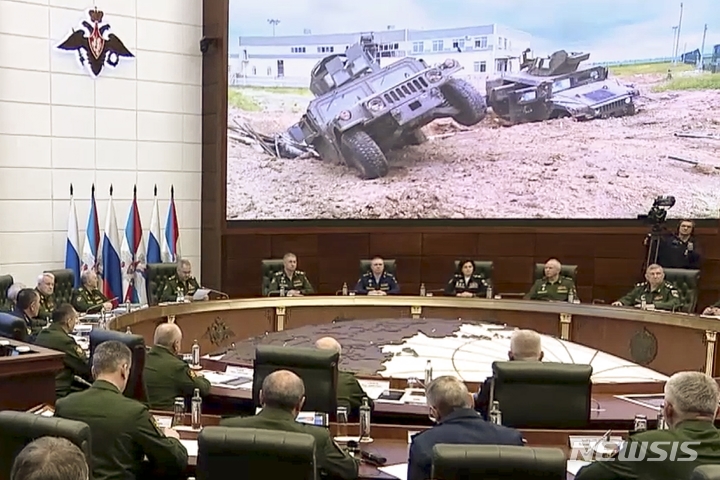 [벨고로트=AP/뉴시스] 러시아 국방부가 제공한 영상 사진으로, 24일(현지시간) 러시아 군 고위급 회의 참석자들 뒤로 서부 벨고로트 지역에서 파괴된 장갑차가 보이고 있다. 2023.05.31.