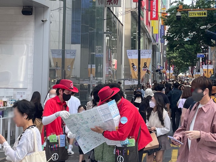 [서울=뉴시스] 임철휘 기자 = 25일 오후 서울 중구 명동거리에서 관광안내원이 관광객에게 길을 안내하고 있다. 2023.05.25. fe@newsis.com *재판매 및 DB 금지