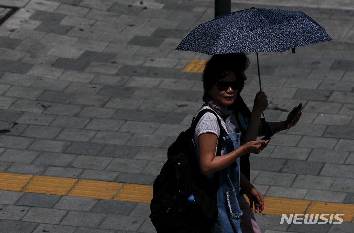 [서울=뉴시스] 정병혁 기자 = 정오부터 오후 3시까지 전국 대부분의 지역에 자외선 지수가 '매우 높음'을 나타낸 25일 오후 서울 중구 세종대로에서 시민들이 양산을 쓴 채 이동하고 있다. 2023.05.25. jhope@newsis.com