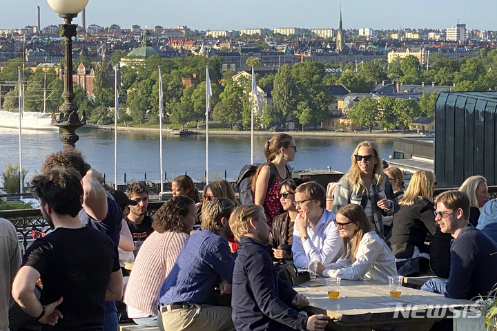 [스톡홀름(스웨덴)=AP/뉴시스]스웨덴 수도 스톡홀름이 내려다보이는 한 식당 야외 테라스에서 30일(현지시간) 시민들이 저녁 햇살을 받으며 음료와 스낵을 즐기고 있다. 15세 이상 인구 흡연율이 5.4%인 스웨덴은 유럽연합(EU) 내에서 흡연율이 가장 낮은 국가로 세계보건기구(WHO)가 '담배연기 없는'(smoke free) 나라로 규정한 흡연율 5% 미만에 근접했다. 2023.05.31.