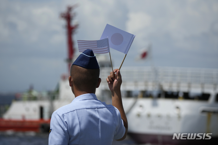 [마닐라=AP/뉴시스]지난 1일 필리핀 해안경비대원이 마닐라 부두에서 열린 환영식에서 성조기와 일장기를 들고 있다. 2023.06.09.