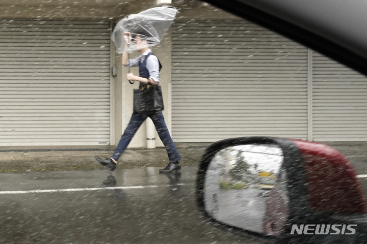 [도쿄=AP/뉴시스] 제2호 태풍 마와르가 일본 도쿄 해상으로 접근하면서 2일 한 도쿄 시민이 우산으로 거친 비바람을 막으며 힘겹게 길을 가고 있다. 2023.06.02.