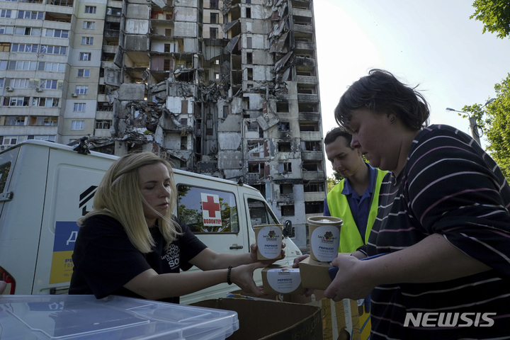 [하르키우(우크라이나)=AP/뉴시스] 러시아군 폭격으로 무너진 하르키우시내 아파트의 주민들이 6월 2일 집근처에서 자원봉사자들이 제공하는 식사를 배급받고 있다. 2023.06.05