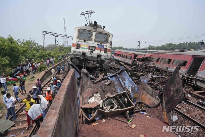 [발라소르=AP/뉴시스] 3일(현지시간) 인도 동부 오리사주 발라소르 지역에서 여객열차 2대와 화물열차 1대가 충돌한 사고가 발생해 구조대원들이 현장을 살펴보고 있다. 2023.06.05.