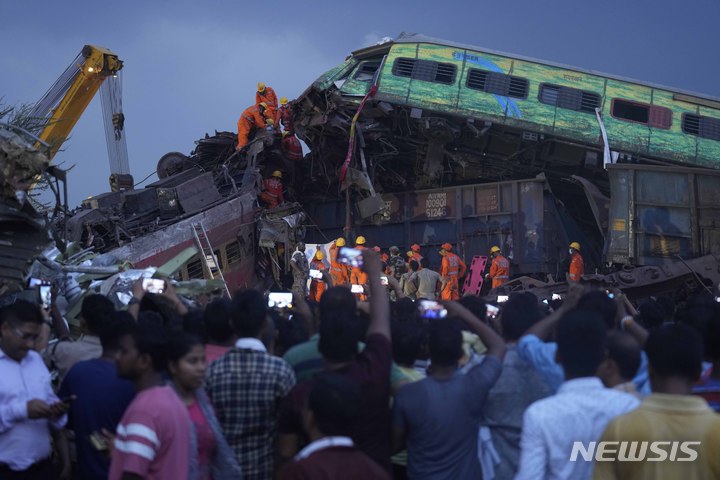 [발라소르=AP/뉴시스] 3일(현지시간) 인도 동부 오리사주 발라소르 지역에서 여객열차 2대와 화물열차 1대가 충돌한 사고가 발생해 구조대원들이 희생자 시신을 수습하고 있다. 2023.06.05.
