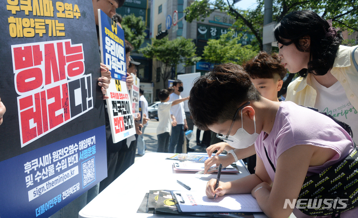 [익산=뉴시스] 김얼 기자 = 더불어민주당 전북도당이 후쿠시마 원전 오염수 해양투기 반대 및 수산물 수입 반대 '국민 서명운동 발대식'을 연 3일 전북 익산시 영등동 무왕로 13길 사거리에서 서명운동에 참여한 어린이들이 진지한 모습으로 서명하고 있다. 2023.06.03. pmkeul@nwsis.com